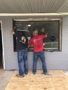 two carolina glass employees install a large custom cut window